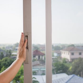 womans hand on a sliding window opening it