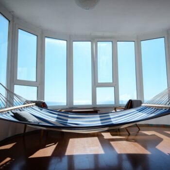 An alignment of bay windows in a room with a hammock